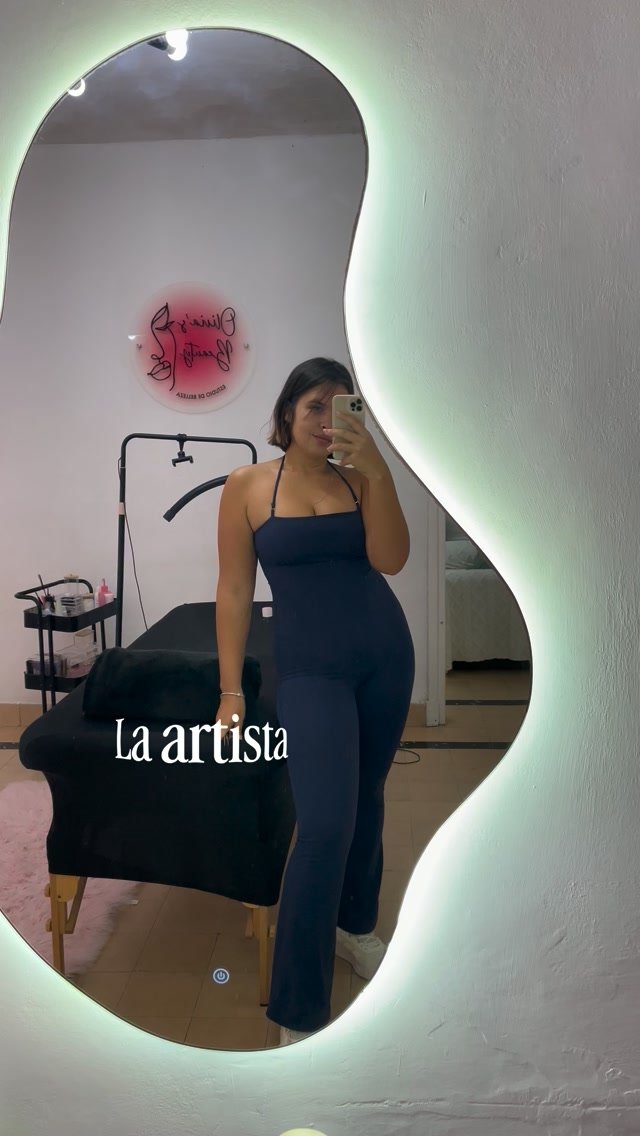 Olivia en el espejo iluminado de su estudio